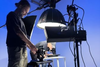 Behind-the-scenes shot of a video production setup with lighting and camera equipment