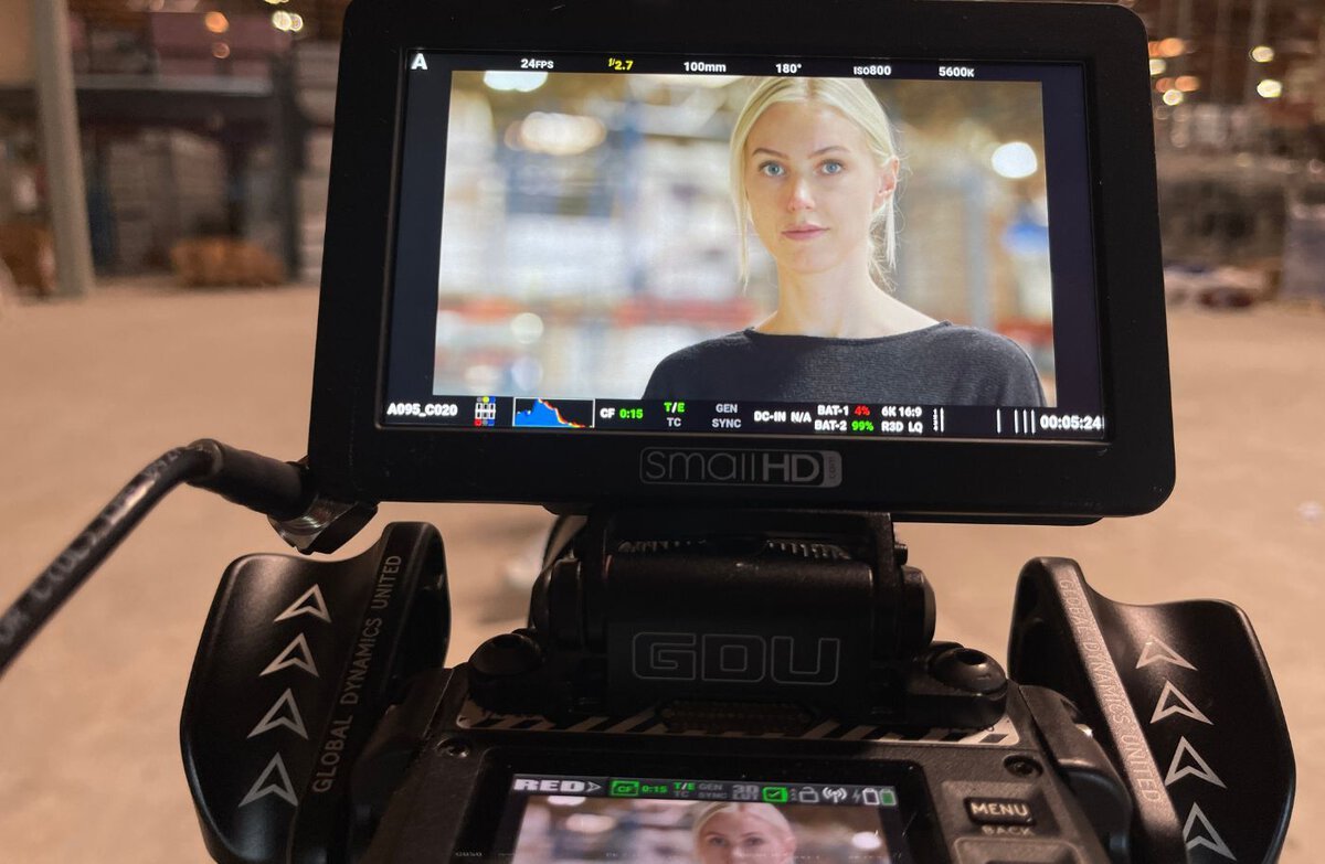 Close-up view of a camera monitor showing a woman during a video shoot