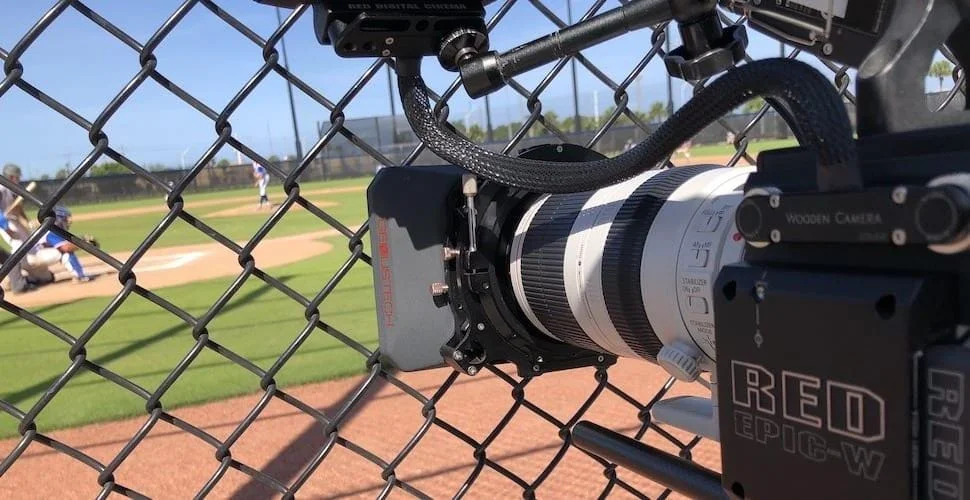 sports videography and video-production-los-angeles Camera filming baseball game through fence